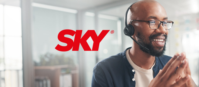 A customer service representative for SKY smiling while on a call.